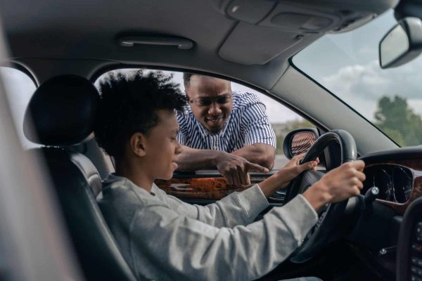 Learner driver at the wheel with an instructor giving direction