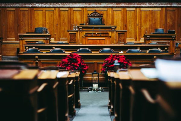 Interior of a wood-panelled courtroom with empty seats